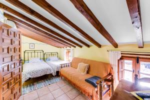 un soggiorno con un divano e due letti di Casa Manadero a Robledillo de Gata