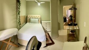 een ziekenhuiskamer met een bed en een spiegel bij Casa verde 4 quartos in Goiânia