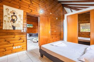 una camera da letto con un letto e una parete di legno di Villa Sofaia à sainte-rose, 9 pers, 3 chambres, vue mer et montagne, piscine privée a Sainte-Rose Altre 40 foto