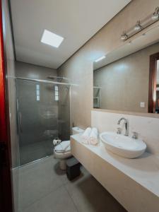 een badkamer met een wastafel, een toilet en een douche bij Hotel Pousada Arcádia Mineira in Ouro Preto