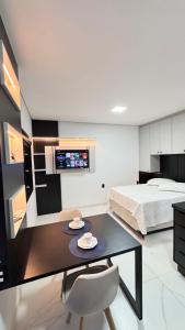a bedroom with a bed and a table with plates on it at Mare Mansa Residence in Florianópolis