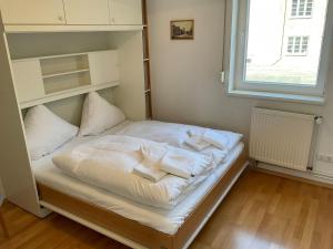 a bed with white sheets and pillows on it at Marienkirche 1 - ABC335 in Wismar