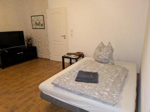 una camera da letto con un letto e una televisione di Ferienwohnung an der Klosterkirche in Nienburg a Nienburg
