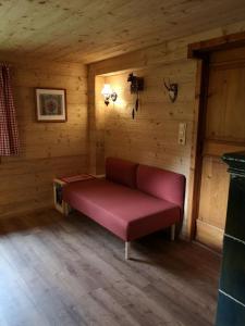 a room with a red couch in a cabin at Hütta Monika in Sankt Gallenkirch
