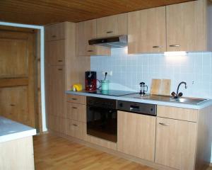 a kitchen with wooden cabinets and a stove top oven at Hütta Monika in Sankt Gallenkirch