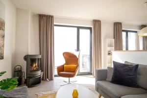 a living room with a chair and a fireplace at Strandhaus Meeresperle in Ostseebad Sellin
