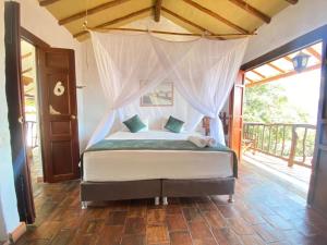 a bedroom with a bed with a canopy at Posada Sueños de Antonio in Barichara