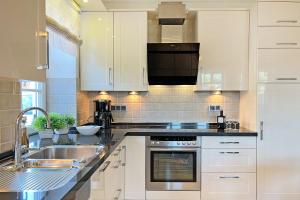 a kitchen with white cabinets and a sink at Wellnessoase in Prerow
