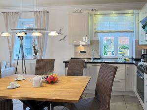 a kitchen with a wooden table and a table and chairs at Wellnessoase in Prerow +17 photos