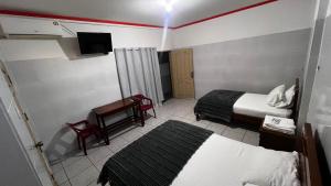 een kleine hotelkamer met 2 bedden en een bureau bij Recidencial NUBE 69 in Santa Cruz de la Sierra