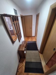 ein Flur mit Holztüren und einem Teppich in der Unterkunft Apartman Mila in Bihać