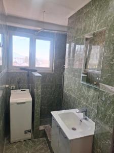 ein Badezimmer mit Waschbecken und Spiegel in der Unterkunft Apartman Mila in Bihać