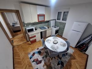 Draufsicht auf eine Küche mit Tisch und Stühlen in der Unterkunft Apartman Mila in Bihać