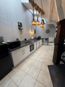 a large kitchen with white cabinets and a table at Loft Des Sens in Saint-Chamond +4 photos