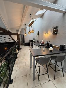 a kitchen with a table and chairs in a room at Loft Des Sens in Saint-Chamond