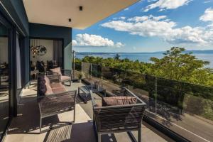 een balkon met stoelen en uitzicht op de oceaan bij Luxury Sea View Villa DIJANA with Infinity Pool & Jacuzzi Near Rijeka in Kostrena