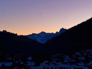 a sunset over a city with mountains in the background at Bellavista Morgins in Troistorrents +2 photos