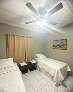 a bedroom with two beds and a ceiling fan at Casa Doña Anita in León