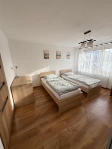 zwei Betten in einem Zimmer mit Holzboden in der Unterkunft Dom Udavské in Udavské