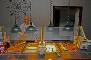 ein Koch steht in einer Küche und bereitet Essen zu in der Unterkunft Best Western Williamsburg Historic District in Williamsburg