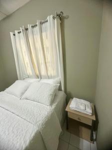 a bedroom with a white bed with a window at Casa Doña Anita in León +3 photos