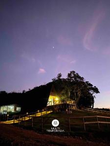 een schuur verlicht 's nachts met een hek bij Rancho Sol Poente - Rancho Queimado - SC in Rancho Queimado