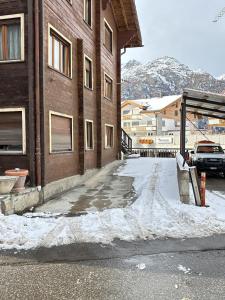 an empty street with snow on the side of a building at Easy Central Stay with Parking in Grächen +2 photos