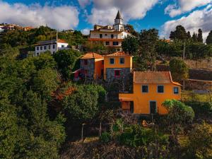 een groep huizen op een heuvel met een kerk bij Madeira-Meerblick-Haus in Estreito da Calheta