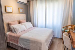 a bedroom with a bed with white sheets and a window at Dookes Apartment in Umdloti +11 photos