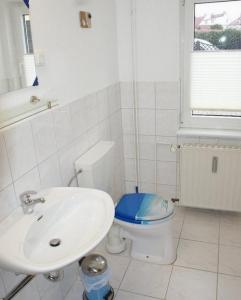 a white bathroom with a sink and a toilet at Ferienhaus Thiess - ABC402 in Wismar