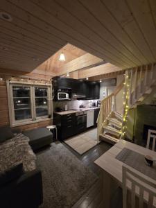 a living room with a staircase and a kitchen at Villa lehto in Kuusamo