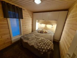 a small bedroom with a bed in a wooden room at Villa lehto in Kuusamo +29 photos