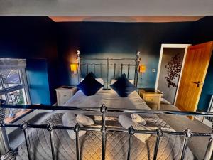 a bedroom with a bed with blue walls at High Street Apartment in Windermere