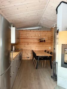 a kitchen with a table and a wooden wall at Honkamaja, Aavasaksa, Lappi, Lapland in Aavasaksa