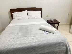 een bed met een wit dekbed en een boek erop bij Recidencial NUBE 69 in Santa Cruz de la Sierra