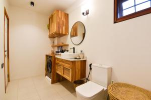 un bagno con lavandino, WC e specchio di Castle Residence Zanzibar a Jambiani Altre 70 foto