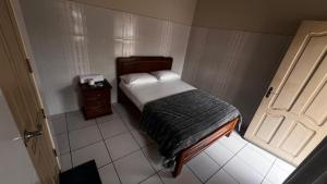 een kleine slaapkamer met een bed en een deur bij Recidencial NUBE 69 in Santa Cruz de la Sierra