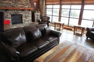 a living room with a leather couch and a fireplace at Rimfire 342: Memory Maker, Walk to Shops, Slope Side in Slaty Fork