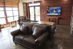 a living room with leather furniture and a flat screen tv at Rimfire 342: Memory Maker, Walk to Shops, Slope Side in Slaty Fork