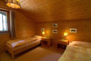 two beds in a wooden room with two lamps at Haus Framgard in Zirkitzen
