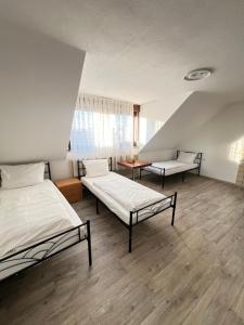 ein Zimmer mit zwei Betten und einem Tisch darin in der Unterkunft FlyInn-Pension Airport-Messe in Leinfelden-Echterdingen