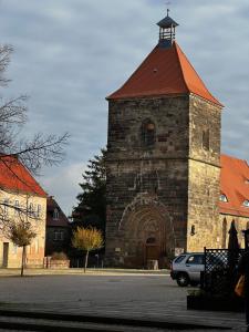 een hoog bakstenen gebouw met een rood dak bij Himmelswege in Niederdorla
