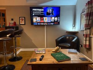 a room with a table with a television on the wall at Bear Cottage in Scyborycoed