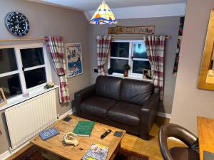 a living room with a couch and a table at Bear Cottage in Scyborycoed