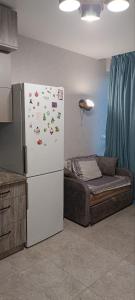 a white refrigerator in a kitchen with a bed at Aкварель на Черемушках in Odesa