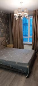 a bedroom with a bed in front of a window at Aкварель на Черемушках in Odesa +19 photos