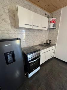 a small kitchen with a refrigerator and a stove at Belén in Mar del Plata
