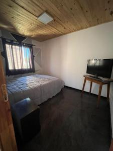 a bedroom with a bed and a flat screen tv at Belén in Mar del Plata