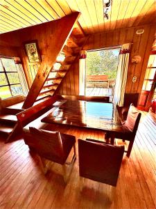 een eetkamer met een houten tafel en stoelen bij Casa de campo Laguna escondida in Chaitén