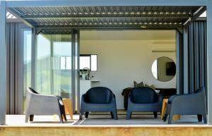 two blue chairs sitting in a room with a mirror at Tihi in Otorohanga